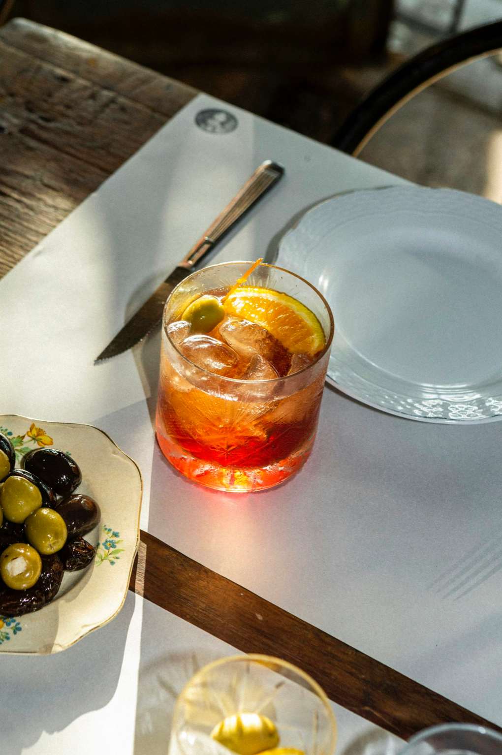 Aperitivo poured over ice with orange and olives